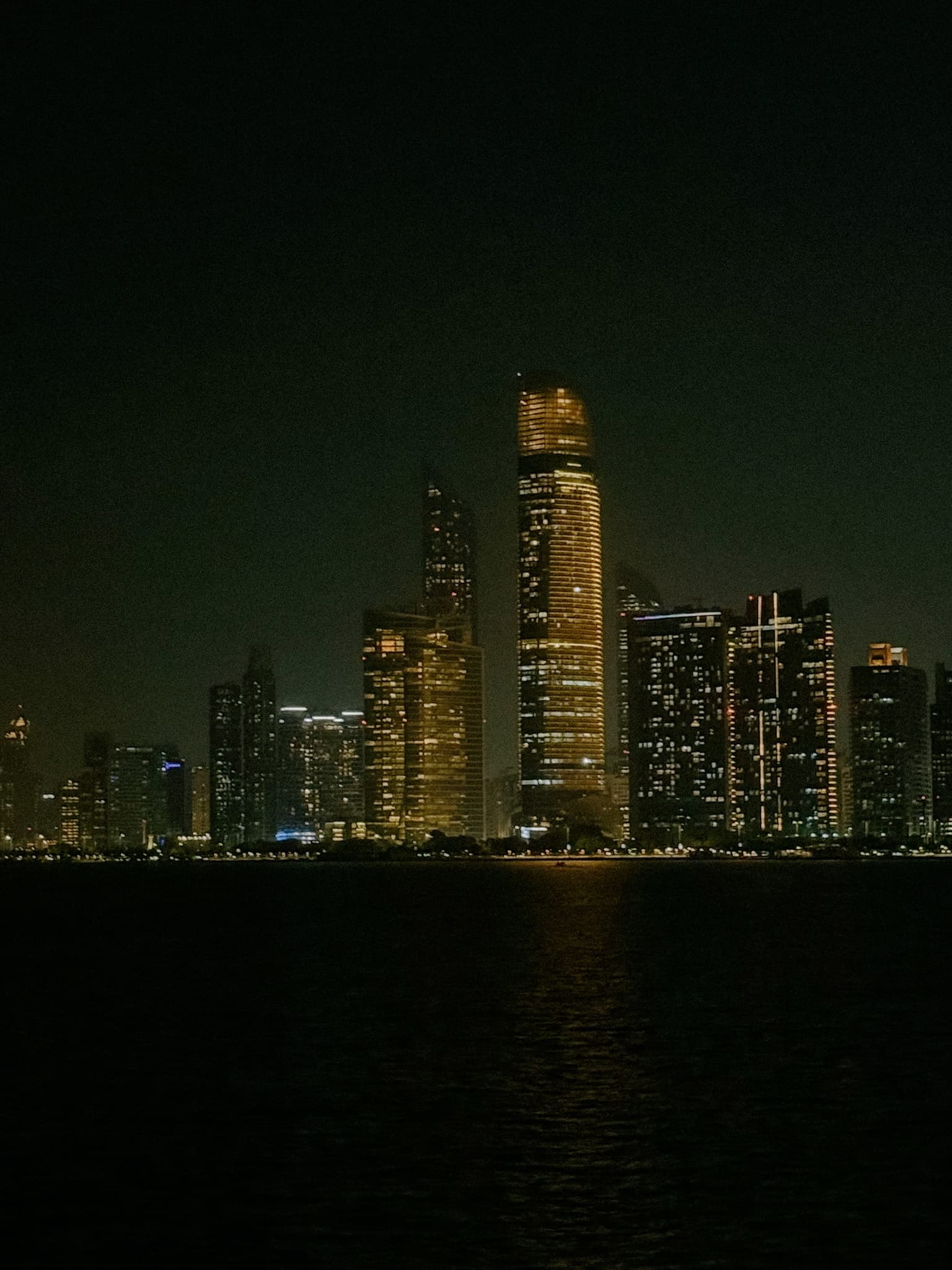 Abu Dhabi skyline at night from breakwater.